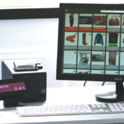 Caisse connectée KerAwen sur un bureau, avec magasin en ligne sur écran de l'ordinateur, imprimante ticket, douchette et afficheur client !