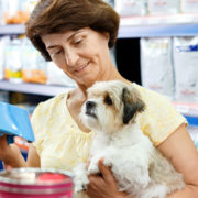 Une dame, avec son chien dans les bras, dans une animalerie équipée du logiciel de caisse KerAwen, logiciel de caisse pour animaleries.