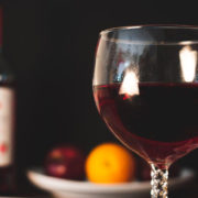 Beau verre de vin sur une table, avec deux bouteilles en arrière-plan.