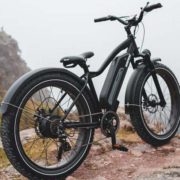 Vélo électrique noir reposant sur sa béquille en haut d'une colline.