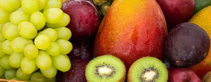 Panier contenant plein de beaux fruits : pommes, ananas, raisin, kiwi...