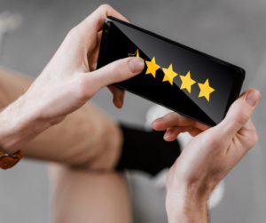 Un client tient dans ses mains un smartphone sur lequel apparaît cinq étoiles de satisfaction client !