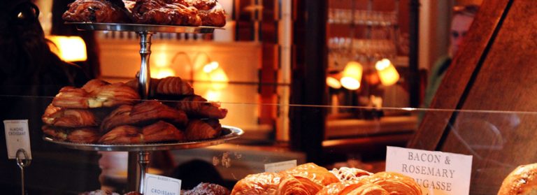 Croissants et viennoiseries derrière la vitrine d'un commerce de détail.