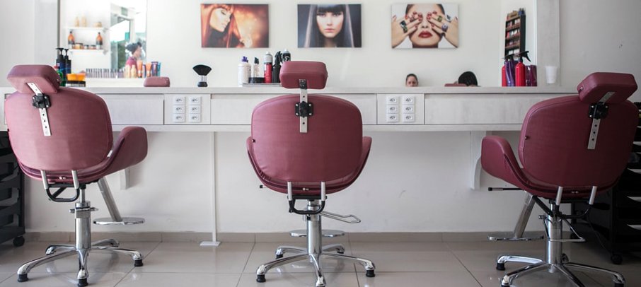 Grande glace et fauteuils à l'intérieur d'un salon de beauté.