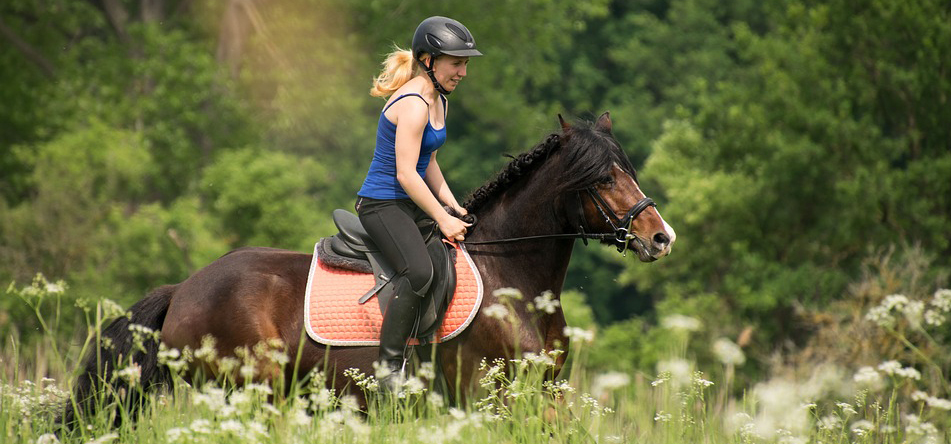Jeune femme à cheval dans la campagne.