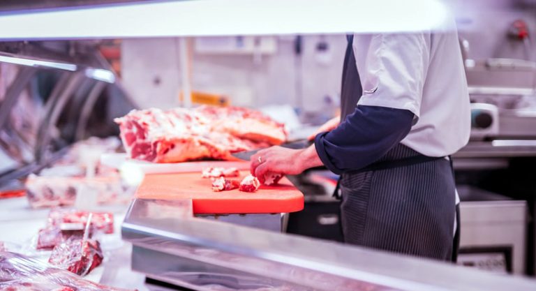 Boucher découpant de la viande.