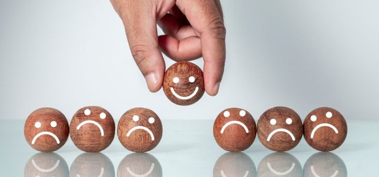 Sept billes en bois sont alignées. Elles ont toutes des yeux et une bouche. Celle du milieu, retirée du rang par deux doigts, est la seule à afficher un sourire. Elle symbolise le seul client satisfait et pris en main, disposant à la fois de bons logiciel de caisse et SAV.