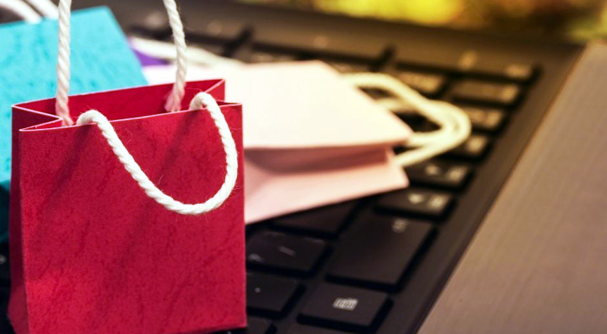 Sacs cadeaux posés sur le clavier d’un ordinateur.
