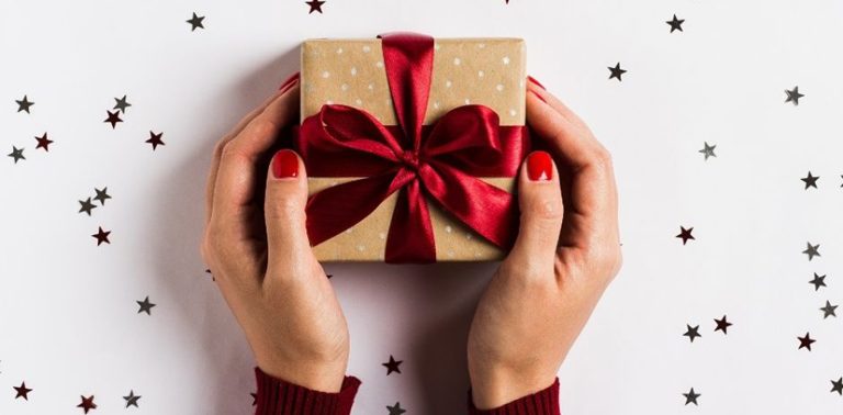 Mains de femmes tenant un petit cadeau de Noël !