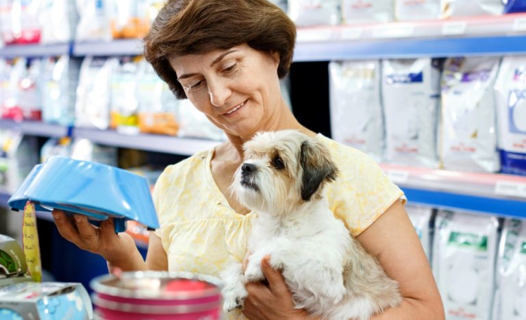 Une dame, avec son chien dans les bras, dans une animalerie équipée du logiciel de caisse KerAwen, logiciel de caisse pour animaleries.