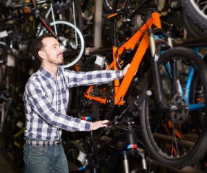 Un jeune vendeur d'un magasin de sport retire un vélo de la réserve.