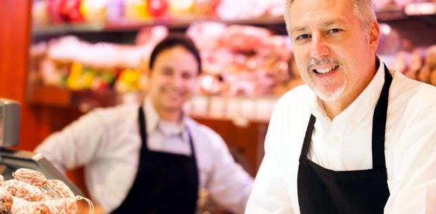 Deux commerçants dans une épicerie, le second est derrière sa caisse équipée d'un logiciel de caisse commerce de détail