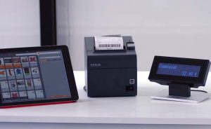Logiciel impression tickets de caisse en pleine action, avec : une caisse sur une simple tablette, une imprimante tickets de caisse et un afficheur client.