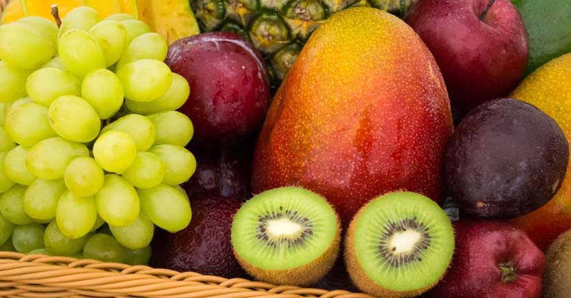Panier contenant plein de beaux fruits : pommes, ananas, raisin, kiwi...