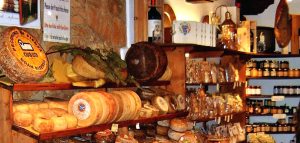 Rayons fromage, charcuterie et vins dans une épicerie fine.