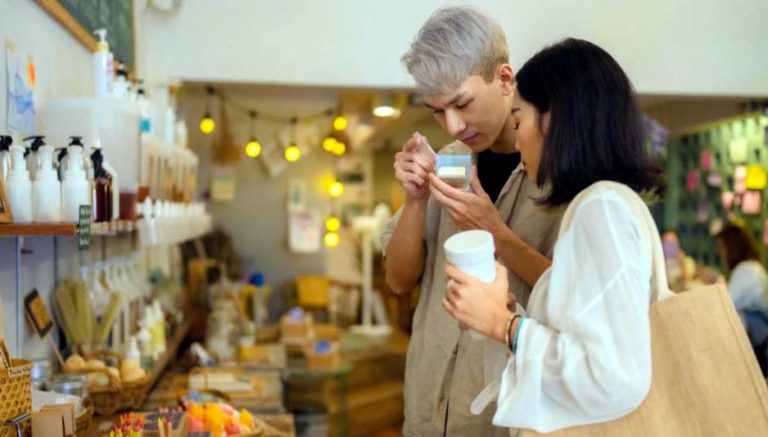 Deux clients très concentrés sentent un produit dans un magasin bio.