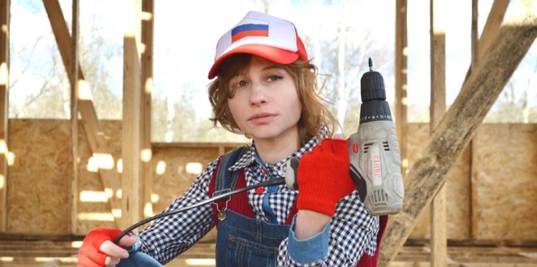 Jeune femme avec une perceuse à la main. Une perceuse achetée dans un magasin possédant un logiciel de caisse pour magasin de bricolage.