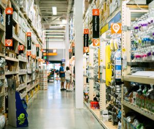 Rayon d'une grande quincallerie avec deux clients effectuant leurs achats.