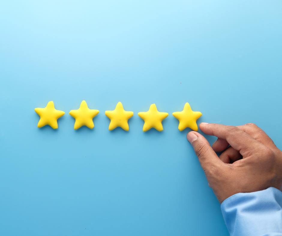 Une main ajoute une étoile à quatre autres sur un site destiné à recueillir les témoignages clients.